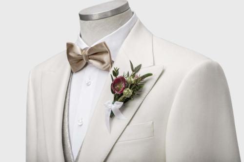 Wit trouwpak op maat gemaakt met goudkleurige strik en gilet